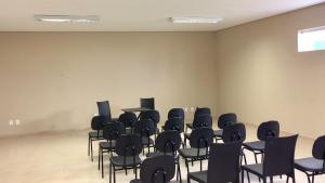 ein leeres Zimmer mit Stühlen und Tischen darin in der Unterkunft Cast Comfort Hotel in Paranaíba