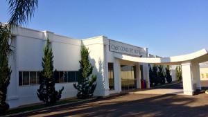 ein weißes Gebäude mit Bäumen davor in der Unterkunft Cast Comfort Hotel in Paranaíba