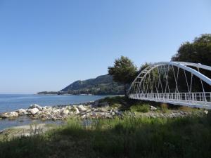 a bridge over the water with a mountain in the background at Germanis House in Agios Ioannis Pelio