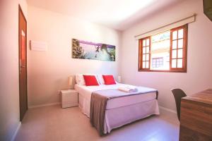 a small bedroom with a bed and a window at CLH Suites Ilha Grande in Abraão