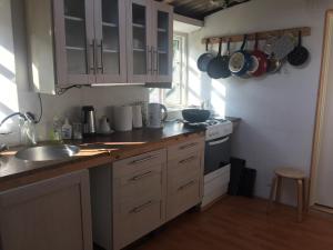 a kitchen with a sink and a stove and cabinets at Rosenlund Bed & Breakfast in Skovsgårde