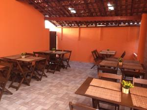 an empty restaurant with wooden tables and chairs at Pousada Pai Nosso in Aparecida