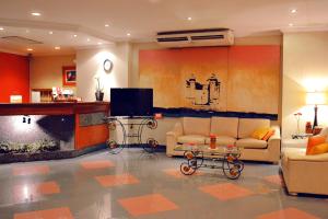 a living room with two couches and a tv at Hotel Manduara in Asunción