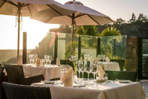 un grupo de mesas con copas de vino y sombrilla en Casa León Royal Retreat en Maspalomas