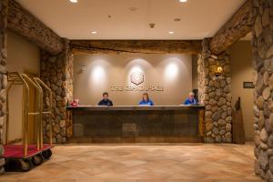 a lobby with people at the counter of a hotel at The Grand Lodge Hotel and Suites in Mount Crested Butte