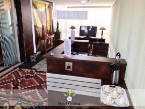 a hotel room with a reception counter with plates on a table at Hotel Garden in Santa Maria