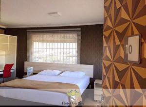 Un dormitorio con una cama grande y una ventana en Hotel Garden, en Santa Maria