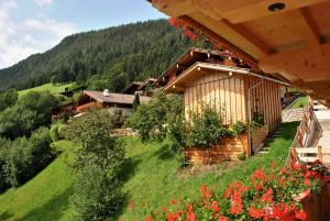 ein Haus auf einem Hügel mit Blumen und Bäumen in der Unterkunft Ferienwohnungen H&P in Alpbach