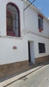 a white building with two windows on a street at Casa Campon in Utrera