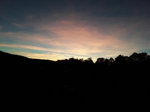 San Miguel de ValeroにあるCasa Rural Costanillaの前景の木々と空の夕日