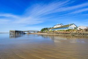 um cais e uma casa numa praia com água em Waters Edge em Salishan Beach