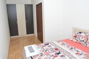 a bedroom with a bed with a red comforter at Novi Apartman in Strumica