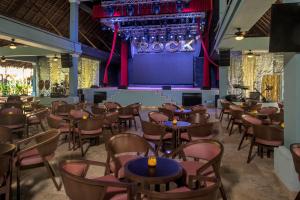 a room with tables and chairs and a stage at Iberostar Waves Tucán in Playa del Carmen