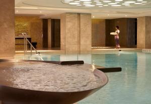 a woman standing next to a swimming pool in a building at Hyatt Regency Istanbul Atakoy in Istanbul