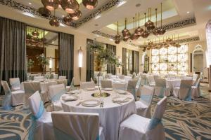 桑給巴爾的住宿－柏悅桑給巴爾酒店，宴会厅配有白色的桌椅和吊灯。