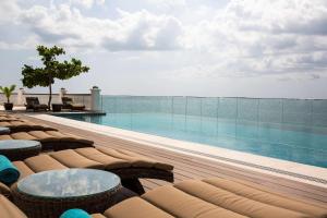 uma piscina com cadeiras e mesas num edifício em Park Hyatt Zanzibar em Zanzibar