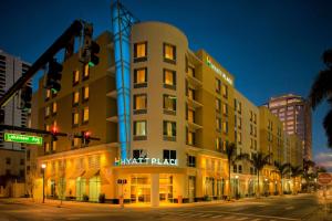 Hyatt Place West Palm Beach في ويست بالم بيتش: مبنى الفندق على شارع المدينة ليلا