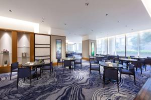 a dining room with tables and chairs and windows at Hyatt Regency Tokyo in Tokyo