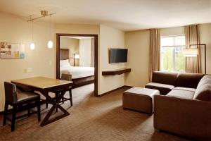- un salon avec un canapé et une table dans une chambre d'hôtel dans l'établissement Hyatt House Seattle Bellevue, à Bellevue
