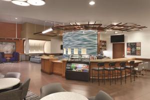 ein Restaurant mit einer Bar mit Stühlen und einer Küche in der Unterkunft Hyatt Place Portland Airport/Cascade Station in Portland