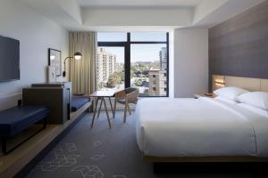オタワにあるAndaz Ottawa Byward Market, By Hyattのベッド、デスク、テーブルが備わる客室です。 +13枚の写真