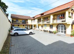 a white car parked in front of a building at Pensiunea Mama Lia in Haţeg