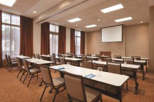 una sala de conferencias con mesas, sillas y una pantalla en Hyatt House Emeryville, en Emeryville