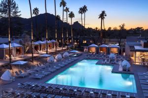 a hotel pool with chairs and palm trees at Andaz Scottsdale Resort & Bungalows in Scottsdale