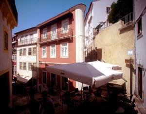 a group of people sitting at a table under an umbrella at cinco em 5 in Coimbra