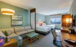 um quarto de hotel com uma cama, um sofá, uma cama e uma secretária em Hyatt Place Boca Raton em Boca Raton