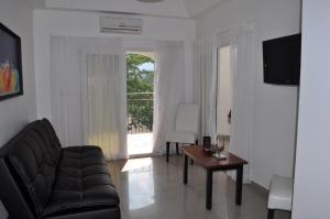 ein Wohnzimmer mit einem Sofa, einem Tisch und einem Fenster in der Unterkunft Hotel Galerias HN in San Pedro Sula