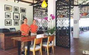 two men standing next to a table in a room at Peppercorn Beach Resort in Phú Quốc