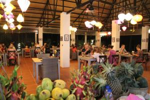 a group of people sitting at tables in a restaurant at Peppercorn Beach Resort in Phú Quốc