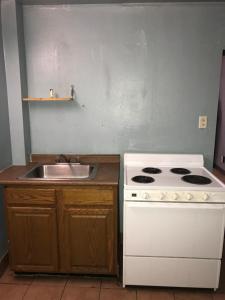 uma cozinha com um fogão branco e um lavatório em Flamingo Motel Marshalltown em Marshalltown