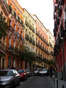 una calle de la ciudad con coches estacionados frente a los edificios en Alma Suites, en Madrid