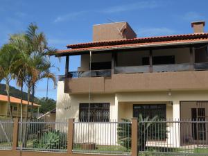 una casa con una valla delante de ella en Bombinhas Brasil Residence II Guest House no Centro, en Bombinhas