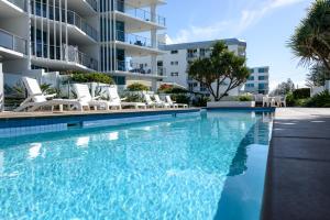 a swimming pool in front of a building at C Bargara Resort in Bargara