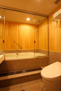 a bathroom with a toilet and a bath tub at Yamaha Resort Katsuragi Kitanomaru in Fukuroi