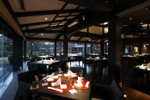 un restaurant avec des tables et des chaises et une grande fenêtre dans l'établissement Yamaha Resort Katsuragi Kitanomaru, à Fukuroi 51 autres photos