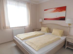 a white bedroom with two beds and a window at Sundance Mountain Resort in Turracher Hohe