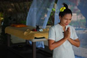 una mujer parada frente a una mesa rezando en KhaoTong Villa at Melina's, en Tha Lane Bay