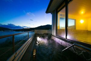a house with a hot tub on the side of a building at Ofunato Onsen in Ōfunato