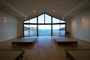 a large room with benches in front of a large window at Ofunato Onsen in Ōfunato