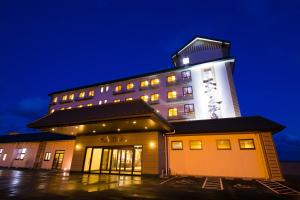 a hotel building with a lit up tower at night at Ofunato Onsen in Ōfunato +40 photos