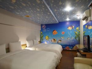sypialnia z 2 łóżkami i ścianą akwarium w obiekcie Day Chen Hotel w mieście Yilan