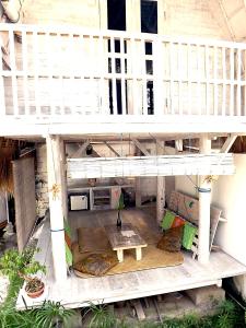 a white balcony with a table and a couch at Uma Nandhi Ubud Natural Cottage in Tegalalang