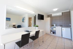 a kitchen with a table and chairs in a room at Caboolture Motel in Caboolture