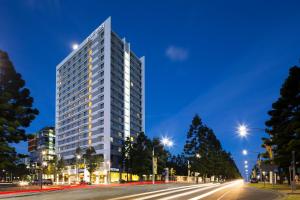 a tall white building on a city street at night at Pullman Sydney Olympic Park in Sydney
