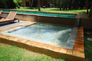 einen Pool mit einer Bank und einem Stuhl im Hof in der Unterkunft Melina Beach Front Bungalows in Tha Lane Bay