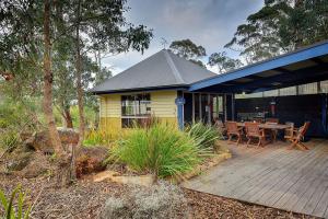 a house with a patio and a tree at Waverley House Cottages in Lakes Entrance